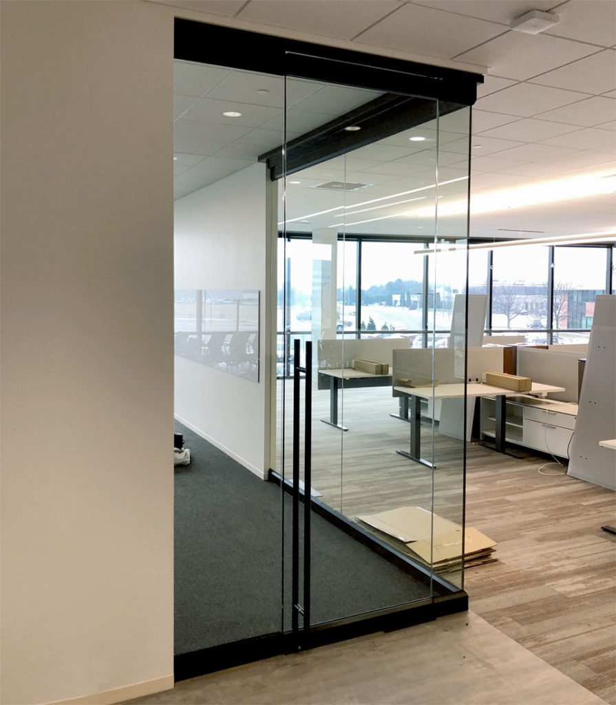 Interior glass corner office has swing door with custom ladder handle