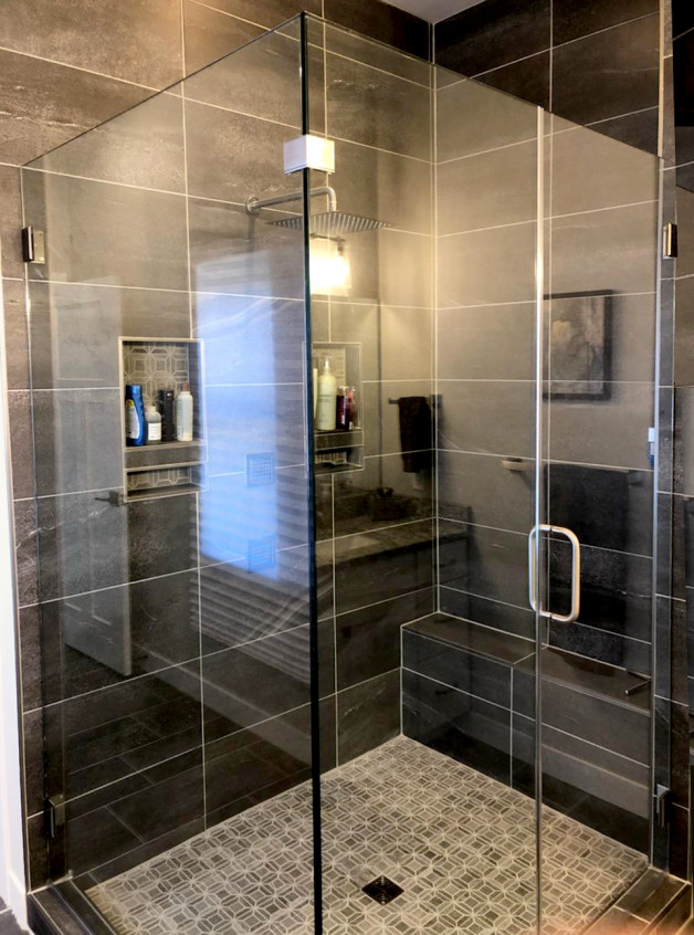frameless clean design shower in dark tiled bathroom
