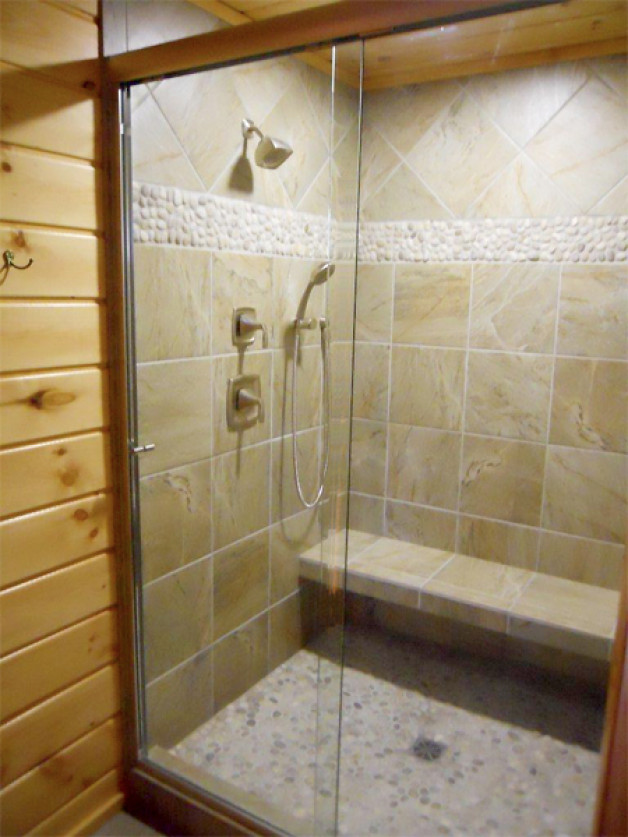 Framelss shower, nicely tiled with bench and nubbly detail, wood paneled bath